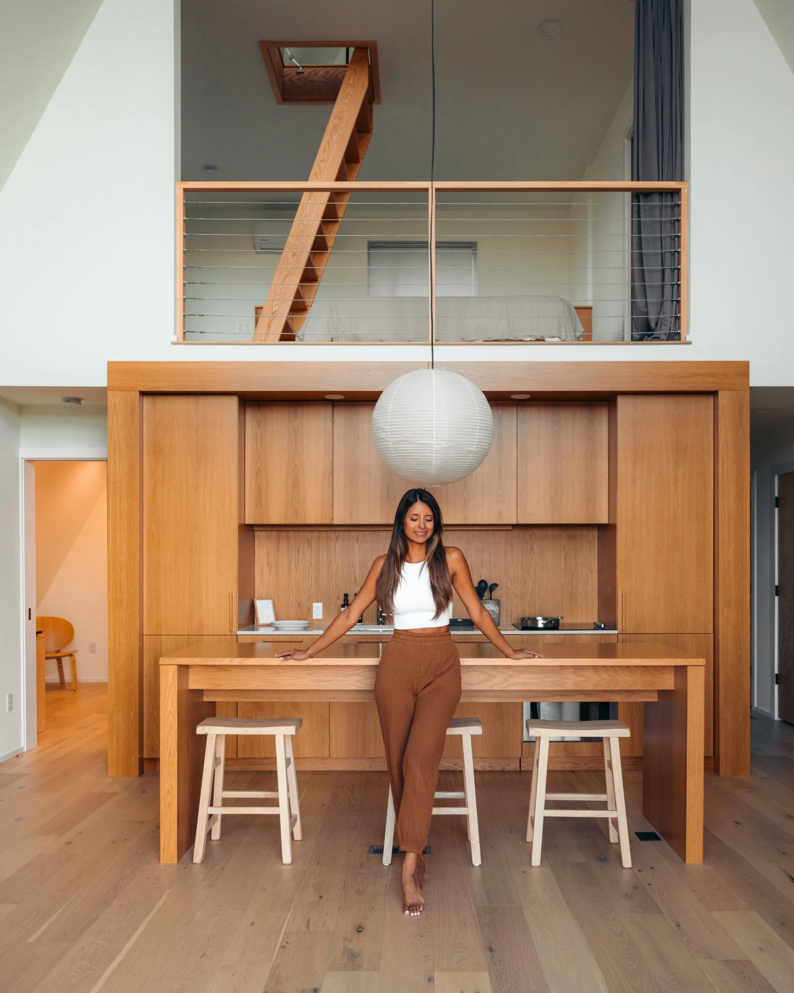 White-oak kitchen island with open loft above at The A-Frame