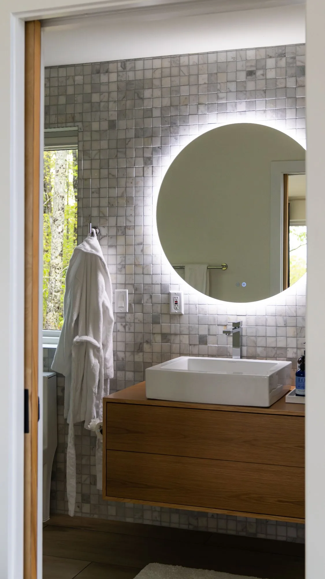Primary bathroom with marble tile and backlit mirror at The A-Frame