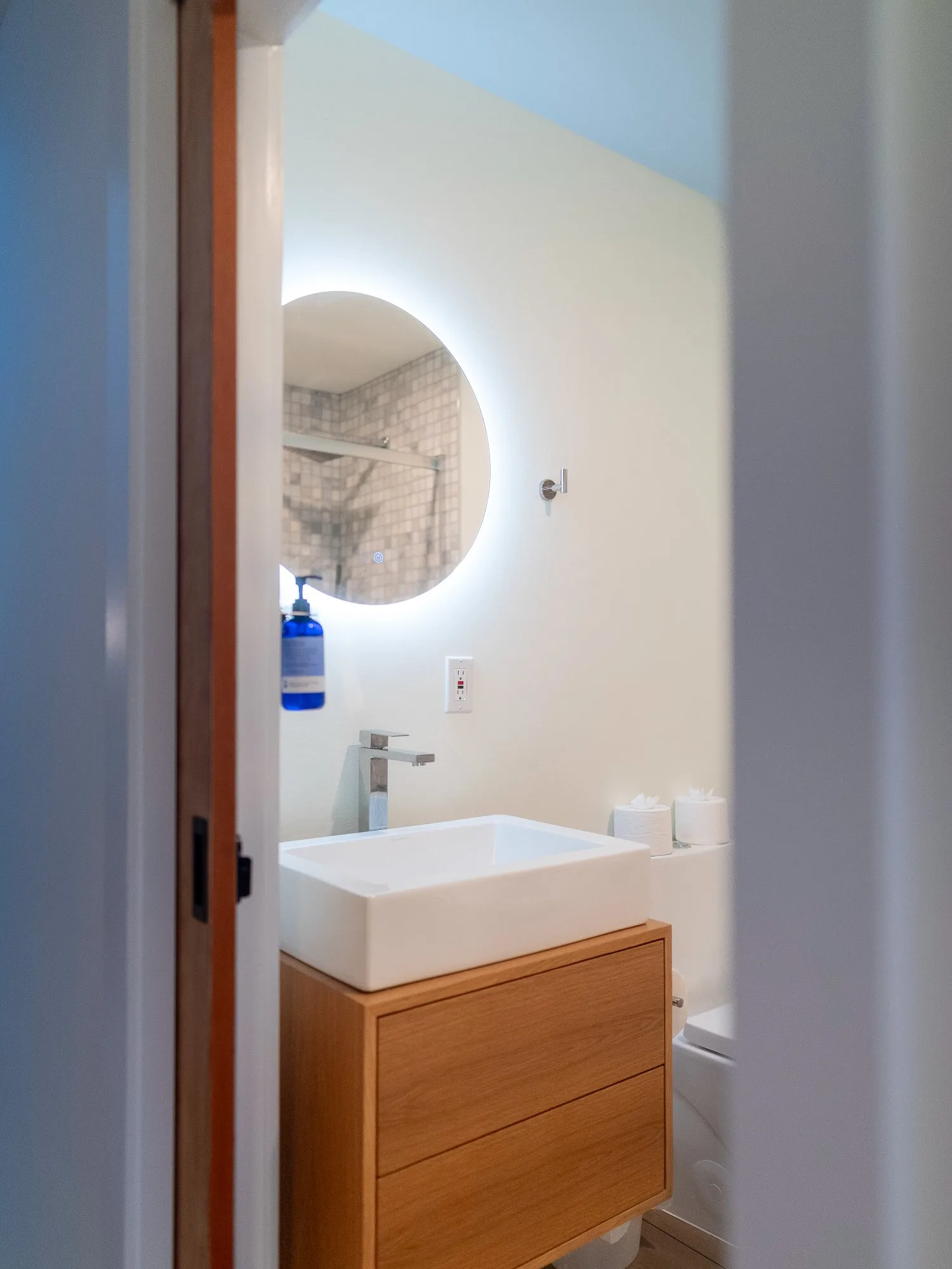 Second bathroom vanity with backlit round mirror at The A-Frame