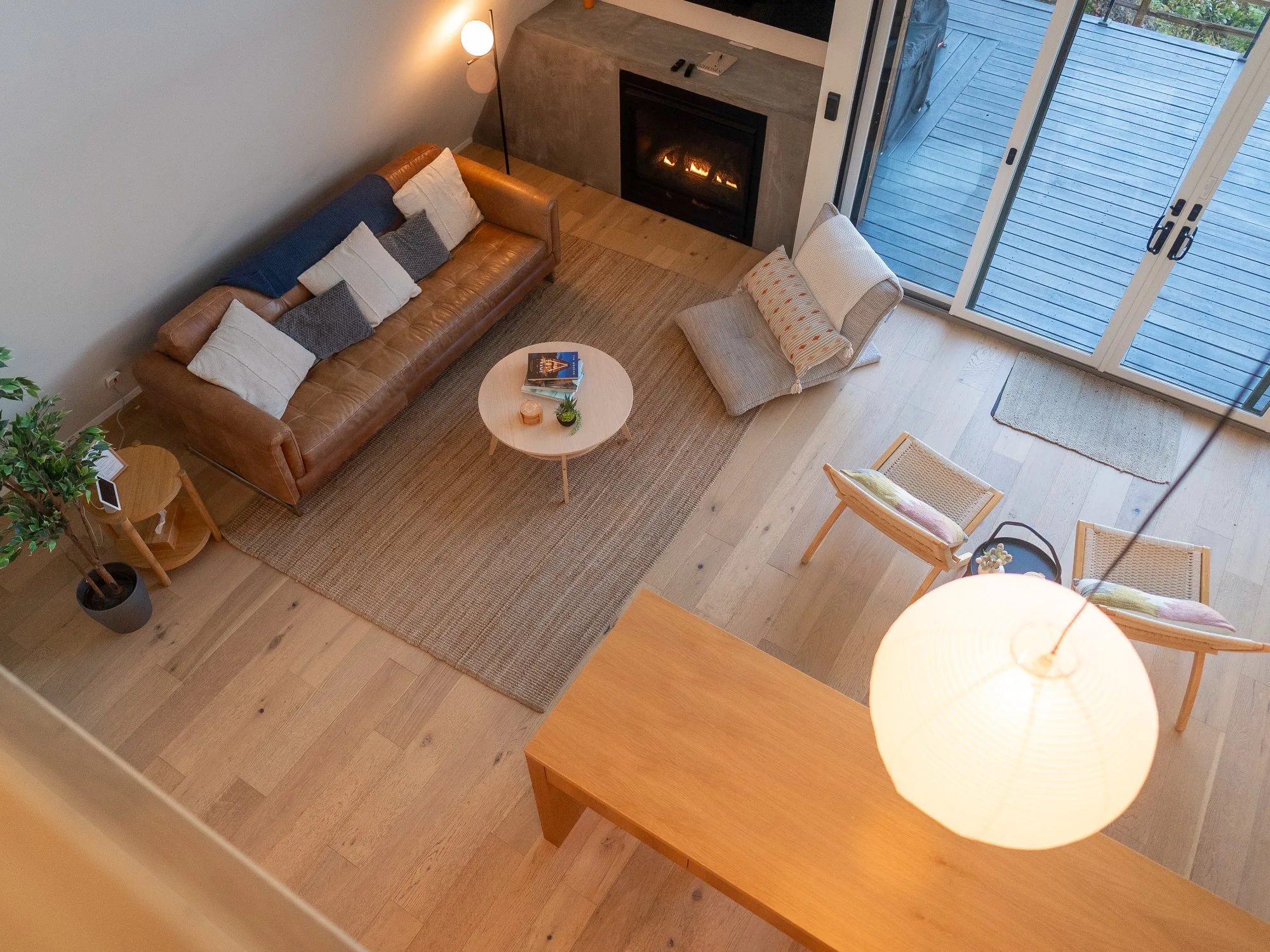 Overhead view of living room with leather sofa fireplace and deck at The A-Frame