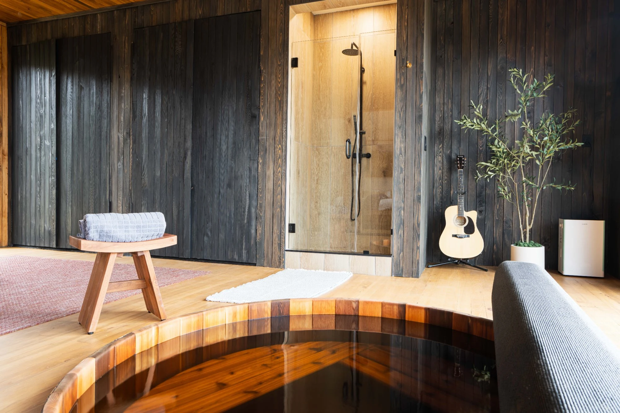 Cedar soaking tub with shower and guitar in Wellness Room at Jackson Point
