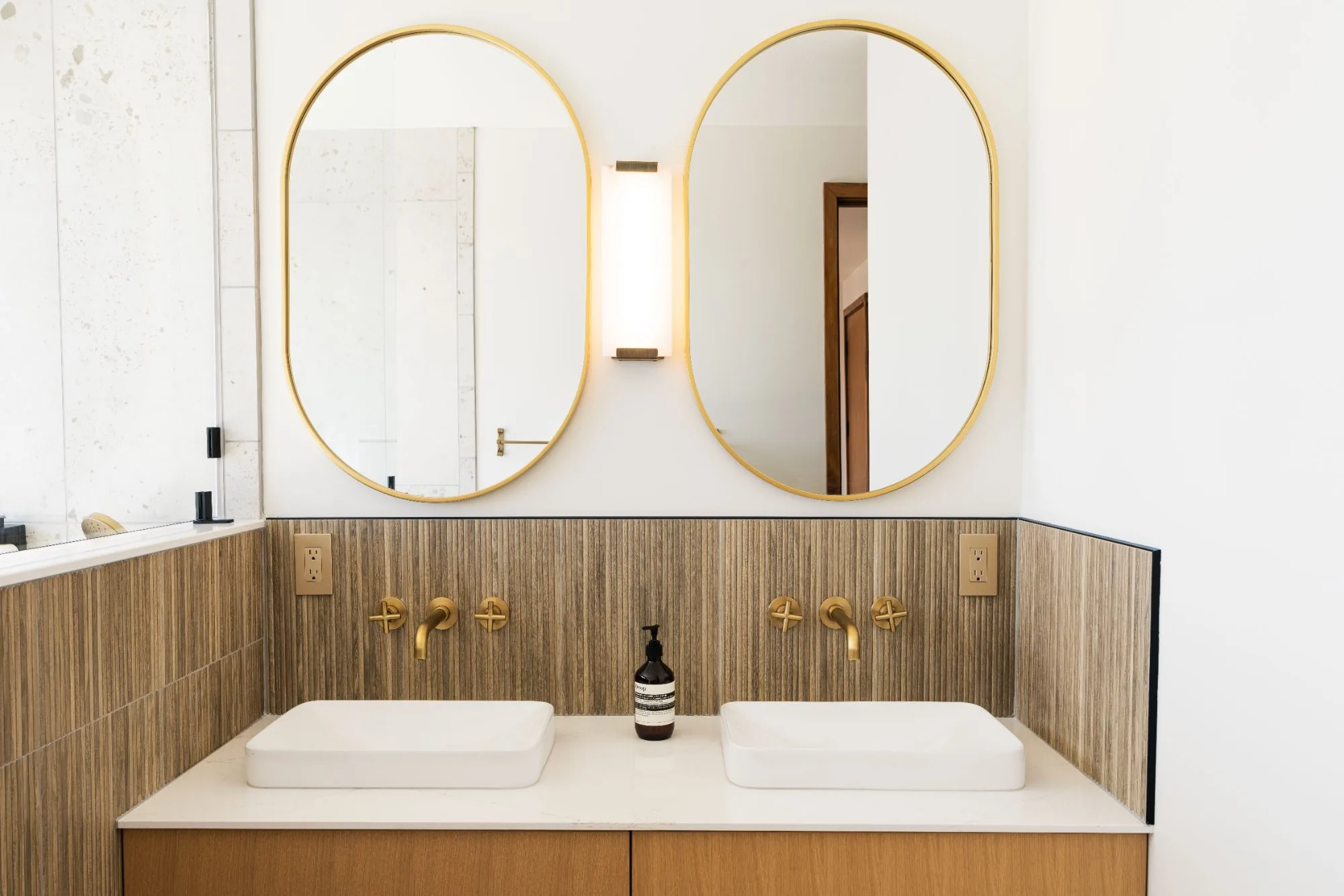 Primary bath double vanity with gold oval mirrors at Jackson Point